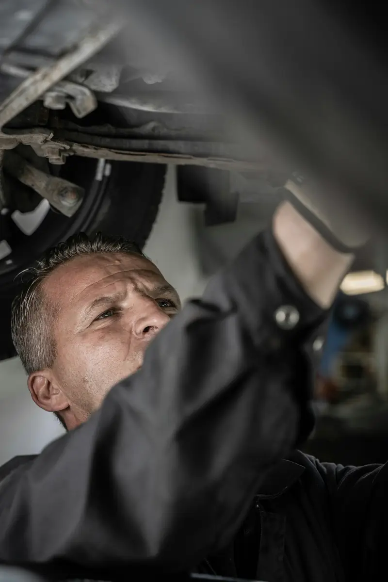 Mecánico revisando los bajos de un coche