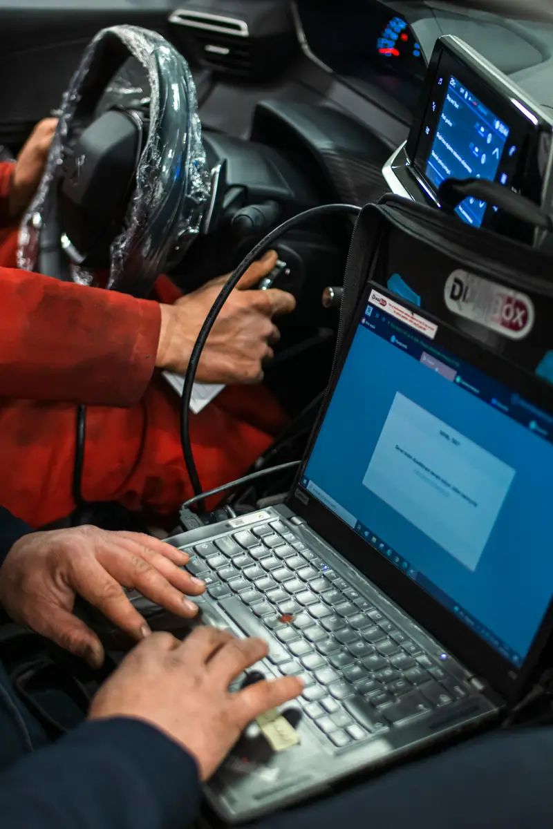 Mecánico conectando un portátil de diagnosis a un coche